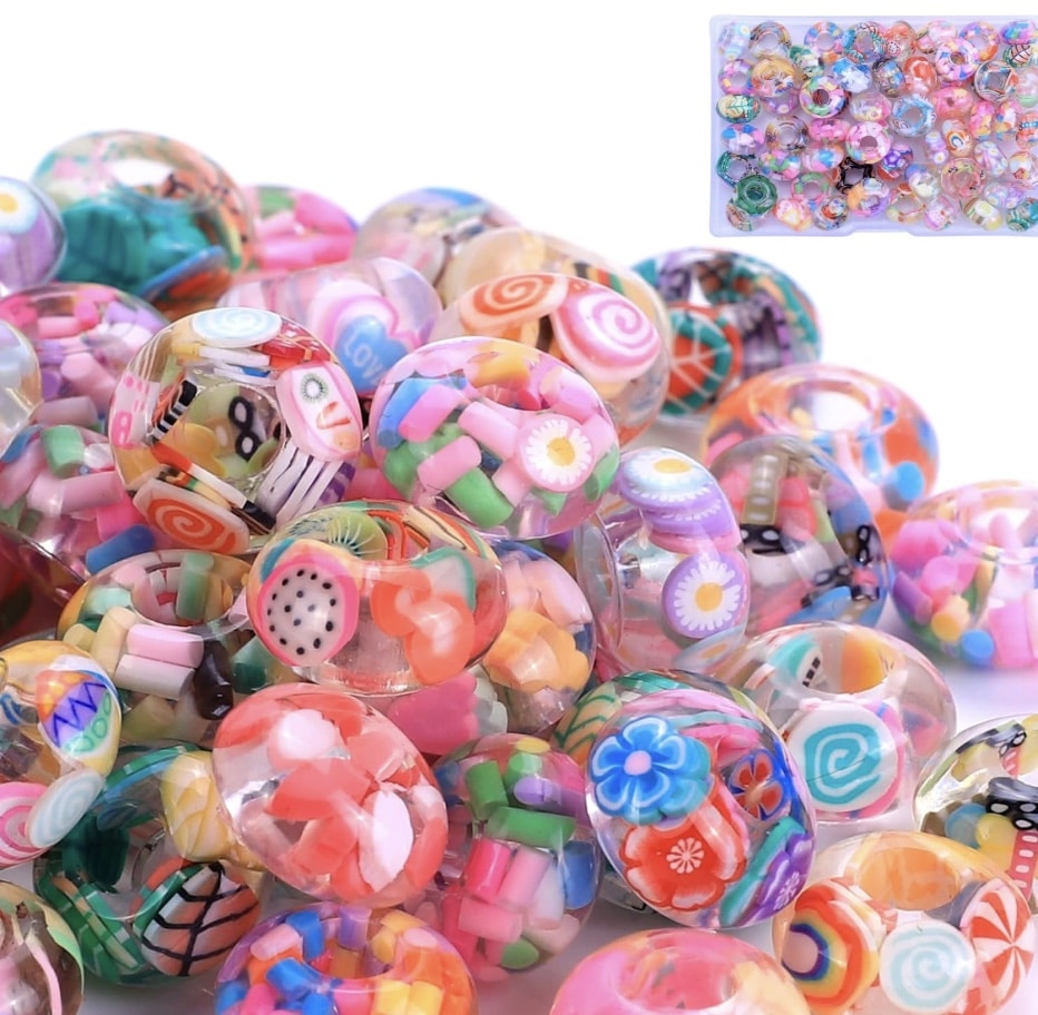 A pile of colorful, round resin beads with embedded miniature designs like flowers, fruit slices, and candies—perfect for beaded garden stakes DIY. In the top right corner, a small image shows more of these decorative beads.